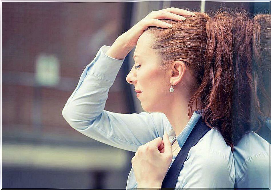 Woman with hand on head because she feels burned at work