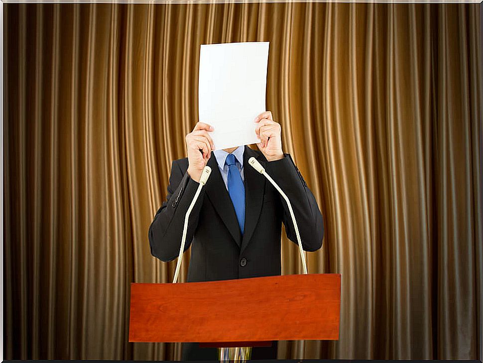 Man covering his face with a sheet of paper