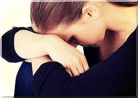 Woman with head resting on knees