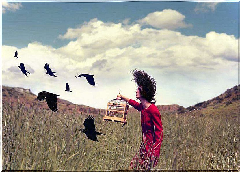 Woman releasing birds from a cage