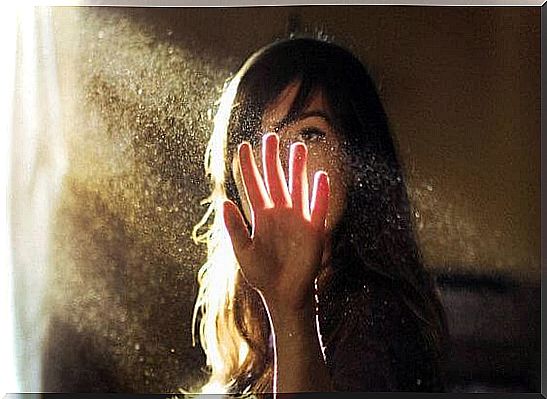 woman with her hand in a beam of light