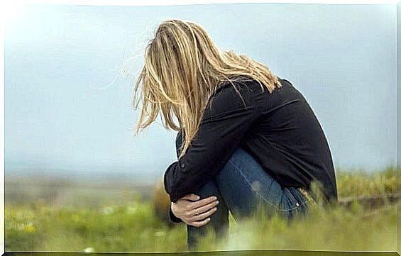 Emotionally insecure woman sitting in the field